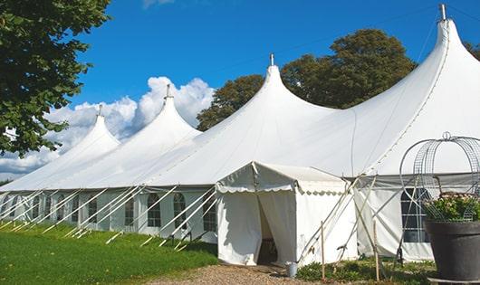 tall green portable restrooms assembled at a music festival, contributing to an organized and sanitary environment for guests in Graysville